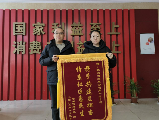 图为桔都西路社区党委书记向南丰烟草赠送锦旗